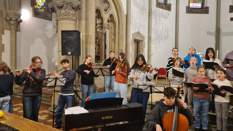 KI generiert: Das Bild zeigt eine Gruppe von Menschen, die in einem kirchlichen Raum musizieren und singen. Es gibt Instrumentalisten, darunter Flötisten und Streicher, sowie einen Chor.